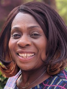 Close up portrait photo of a smiling black woman, a local carer called Margaret