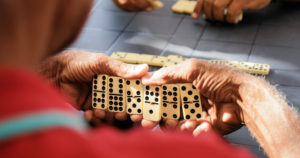 photo showing older black male hands holding dominoes