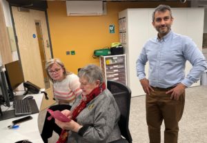 three people in reception area of GP practice 