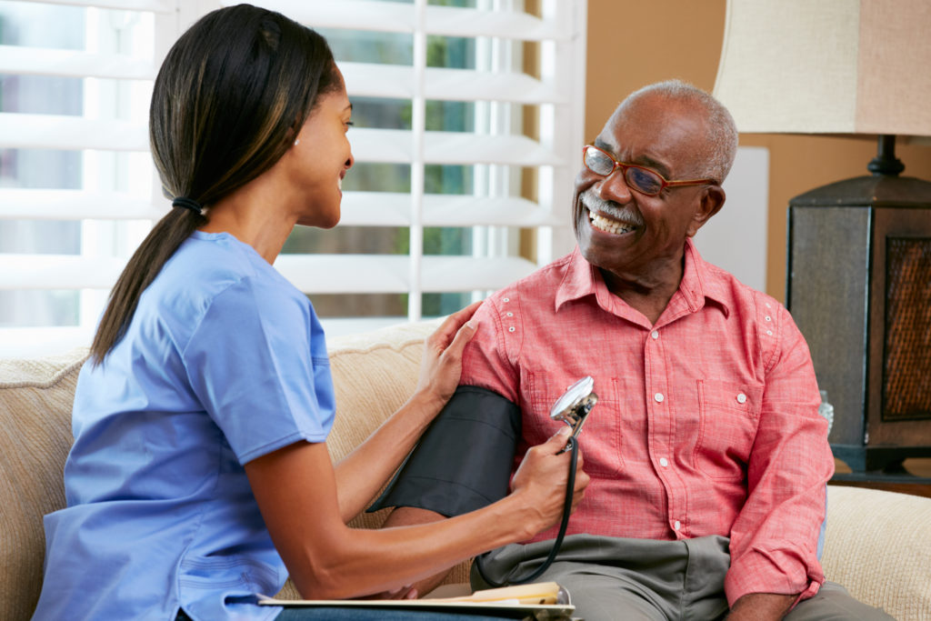 Older Black man having blood pressure checked 