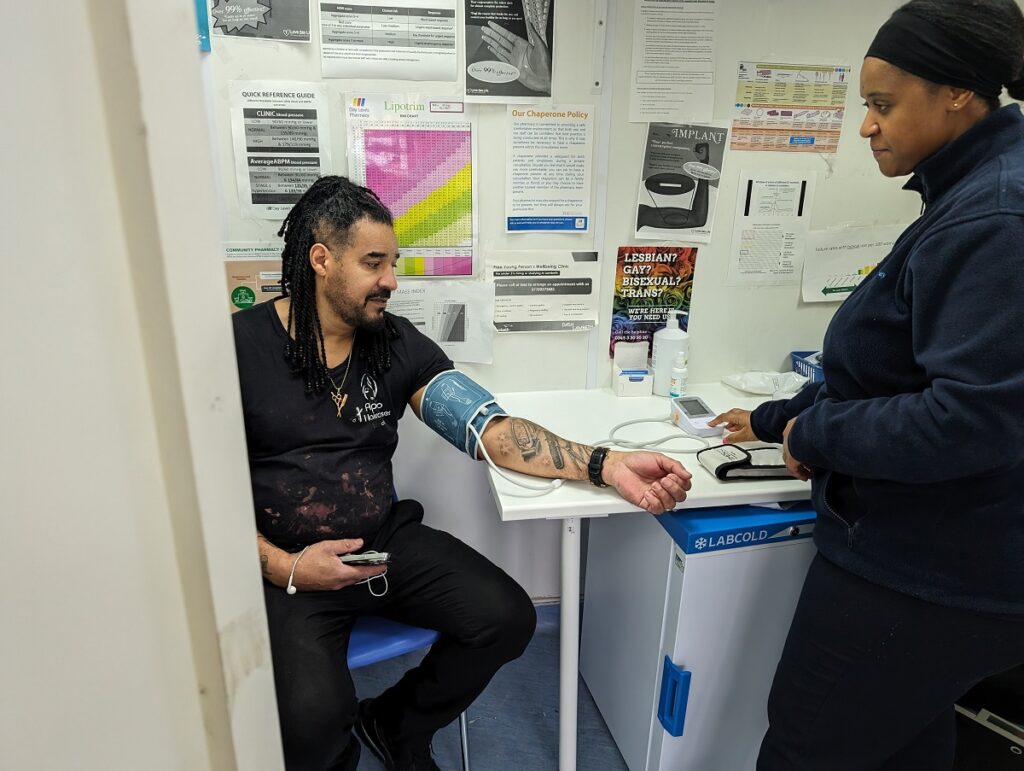 A local hairdresser getting his blood pressure checked at a Lambeth pharmacy