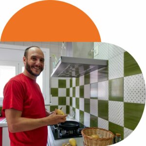 Man smiling, preparing a meal in his kitchen