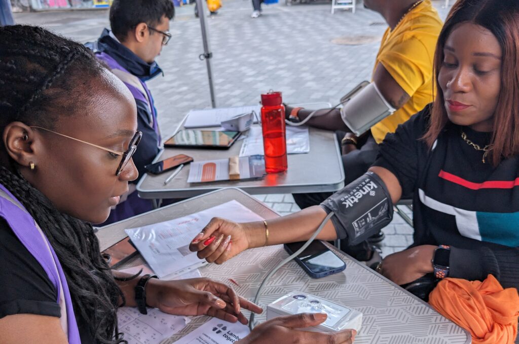 Pharmacists giving blood pressure check at the Health and Wellbeing Bus for May Measurement Month