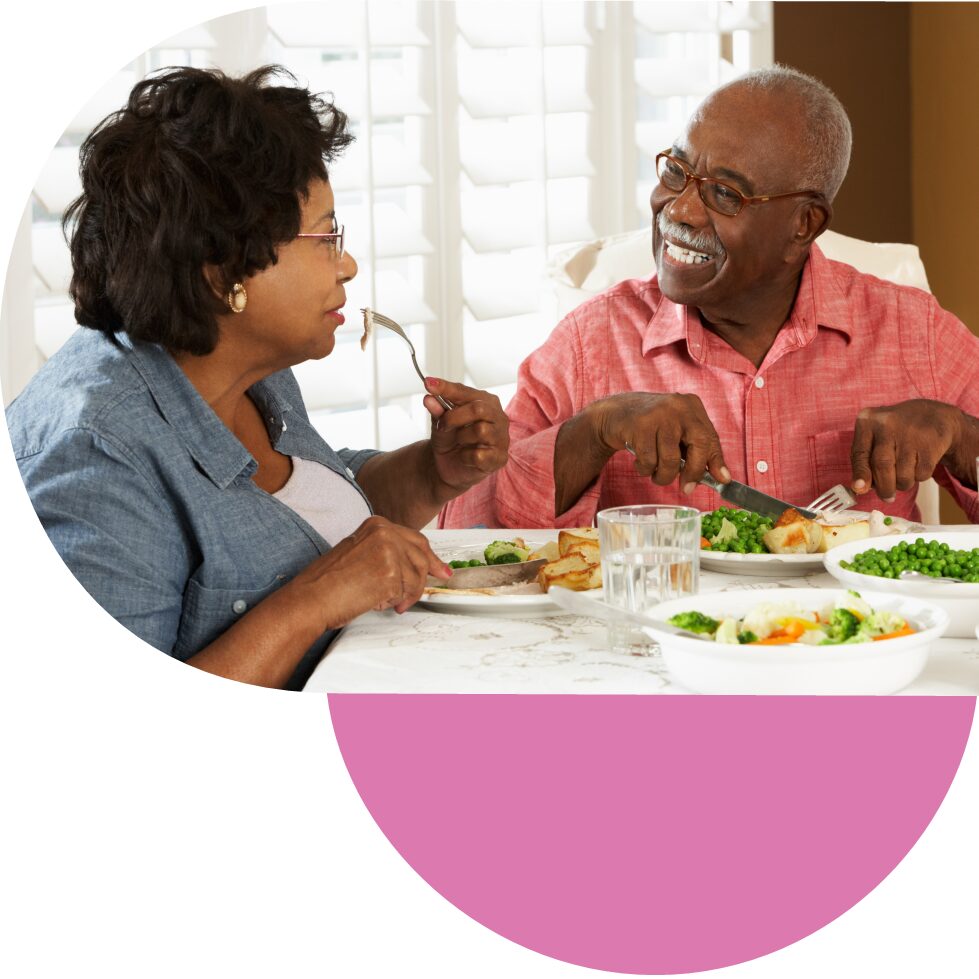 Elderly couple sitting, eating dinner together and talking 